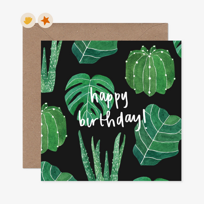 Dark green card with green watercolour plants and leaves with the words &quot;Happy Birthday!&quot; in a white script font.