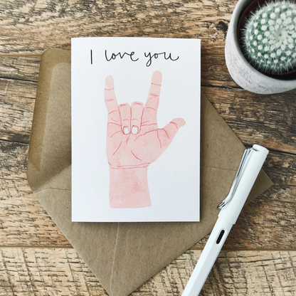 Card with a light skinned hand doing the &quot;I Love You&quot; sign language sign with the words &quot;I love you&quot; in a script font.