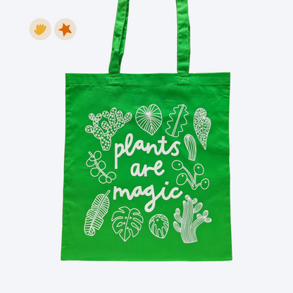 Green tote back with white plants and leaves doodles on and the words &quot;plants are magic&quot; in a playful font. 